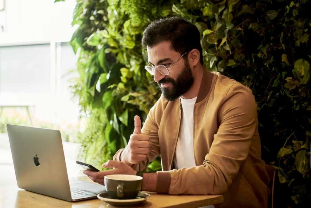 A bearded man with glasses working on a laptop
