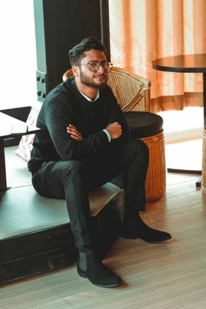 A man with glasses sitting with crossed arms